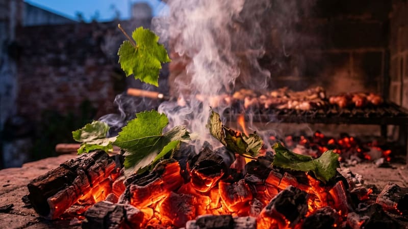 Arrojar hojas de parra sobre las brasas del asado: para qué sirve y por qué miles de parrilleros lo hacen.