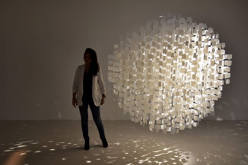 A visitors poses in front of an artwork titled 'Sphere blache' by French-Argentinian artis Julio Le Parc during the international contemporary art fair ARCO in Madrid on February 23, 2017. / AFP PHOTO / JAVIER SORIANO