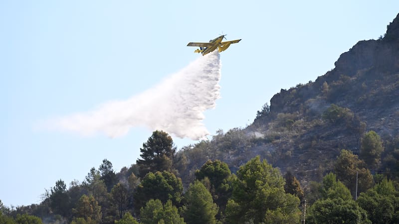 SONEJA (CASTELLÓN), 06/07/2026.- Una avioneta de la lucha contra el fuego descarga agua para la extinción del incendio forestal de Soneja (Castellón), que este domingo obligó al desalojo de 500 personas del vecino municipio de Azúebar y hasta el momento ha afectado a unas 150 hectáreas de superficie y a una pequeña parte del parque natural de la Sierra de Espadán. EFE/ Andreu Esteban
