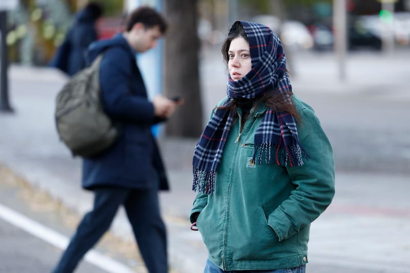 MADRID, 01/12/2025.- Una mujer se protege del frío mientras camina por Madrid, este lunes. El primer día de diciembre arranca con temperaturas mínimas bajo cero en la Comunidad de Madrid, con heladas débiles generalizadas en la región, según el pronóstico de la Agencia Estatal de Meteorología (Aemet). Las mínimas estarán descenso mientras las máximas subirán ligeramente superando los diez grados. Los cielos estarán velados de nubes altas y el viento soplará flojo variables. EFE/ Mariscal