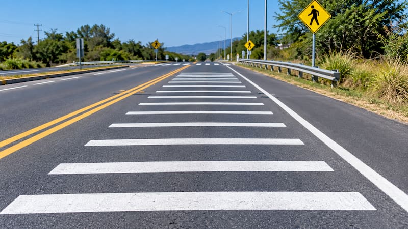 La NOM-034-SCT2/SEDATU-2022, vigente para la señalización y los dispositivos viales en calles y carreteras, las identifica oficialmente como “Rayas con espaciamiento logarítmico (M-9)”. (Representación creada con IA)