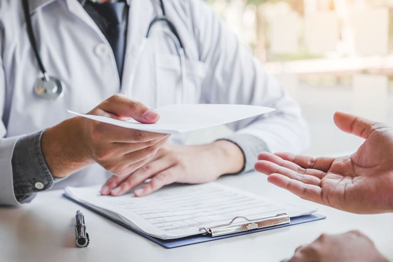 Médico entregando un certificado médico. Fuente: Shutterstock