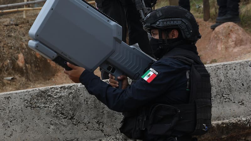 MEX2603. CHILAPA (MÉXICO), 12/05/2026.- Un policía estatal custodia con un arma antidrones la zona donde ocurrió un enfrentamiento este martes, en Chilapa, estado Guerrero (México). La secretaría de Gobernación de México, Rosa Icela Rodríguez, acudió a Chilapa acompañada de efectivos del Ejército y la Guardia Nacional para retirar bloqueos, atender a desplazados y evacuar heridos, en medio de una crisis de violencia que el Gobierno federal atribuyó a la disputa entre dos grupos criminales: Los Ardillos y Los Tlacos. EFE/José Luis de la Cruz