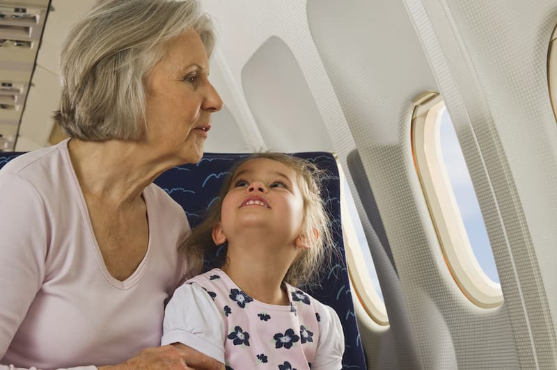 Mujer adulta viaja en avión con una niña. Imagen ilustrativa de la nota.