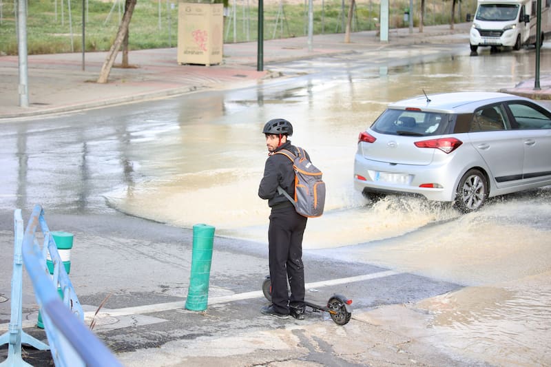 CABEZO DE TORRES (MURCIA), 28/12/2025.- Un viandante pasa junto a una carretera inundada en la población murciana de Cabezo de Torres este domingo tras las lluvias torrenciales registradas la pasada madrugada. EFE/Juan Carlos Caval