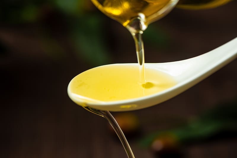 El aceite de girasol actúa como base: su textura densa retiene los compuestos aromáticos de los otros ingredientes y los libera de forma progresiva.
