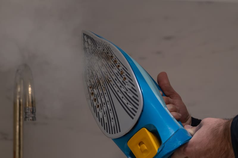 Otro método casero muy utilizado consiste en calentar la plancha a temperatura moderada y pasar una vela sobre la base para que la cera ayude a desprender los restos adheridos. (Fuente: Shutterstock)