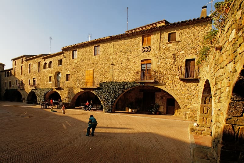 La Plaza Jaume I es el corazón de Monells. Antiguo mercado de cereales, hoy es uno de los espacios más fotografiados de Girona.