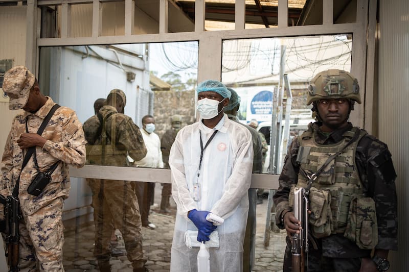 Un trabajador con bata protectora se prepara para tomar la temperatura a los visitantes como medida preventiva contra el ébola en el Instituto Nacional de Investigación Biomédica (INRB) en Goma, Kivu del Norte, República Democrática del Congo.