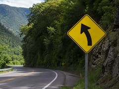 Qué significa la señal de tránsito con una flecha con curva en diagonal en fondo amarillo y bordes negros