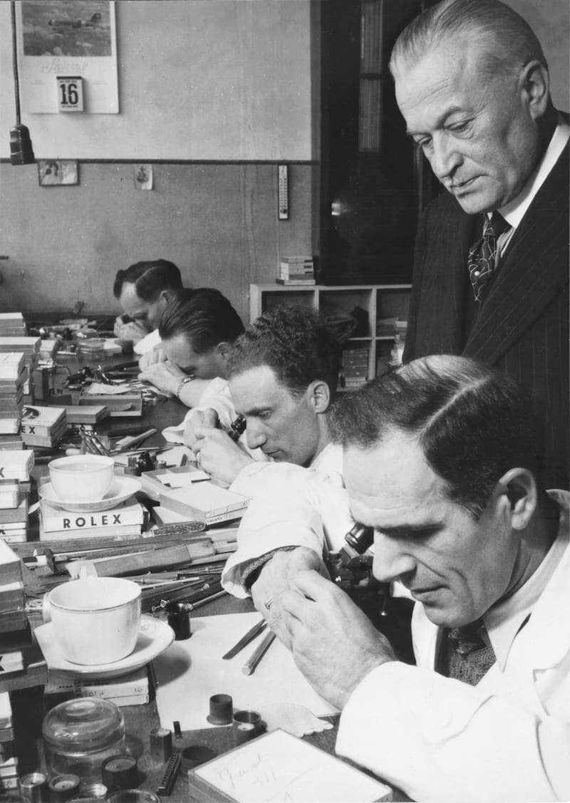 Hans Wilsdorf en los talleres de Rolex en la rue du Marché con relojeros trabajando.