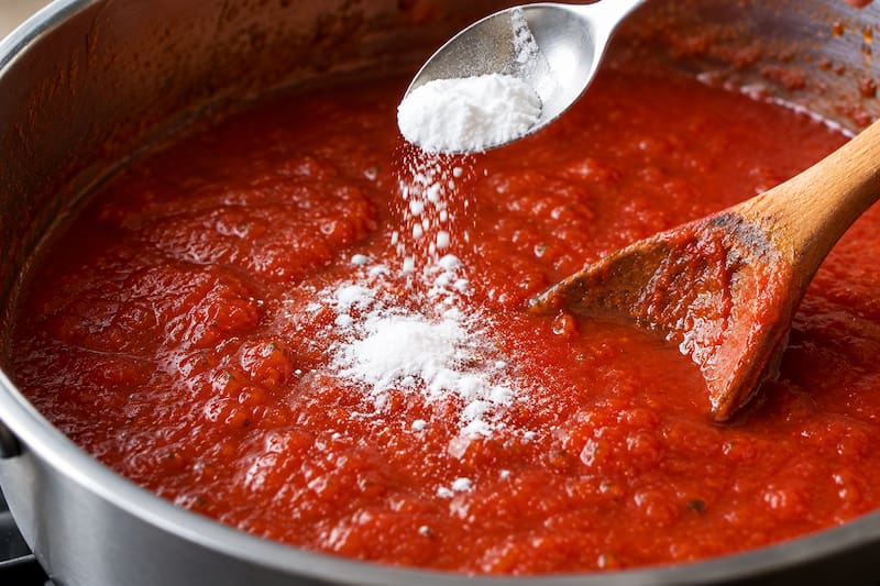 El bicarbonato de sodio es un compuesto alcalino que reacciona con los ácidos presentes en el tomate. (Fuente: IA)