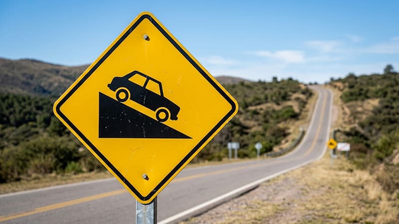 Qué significa la señal de tránsito de un auto que baja por un triángulo y por qué es importante