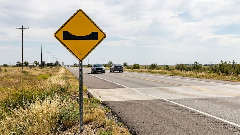 Qué significa la señal de tránsito amarilla con una base recta y una curva en el centro.