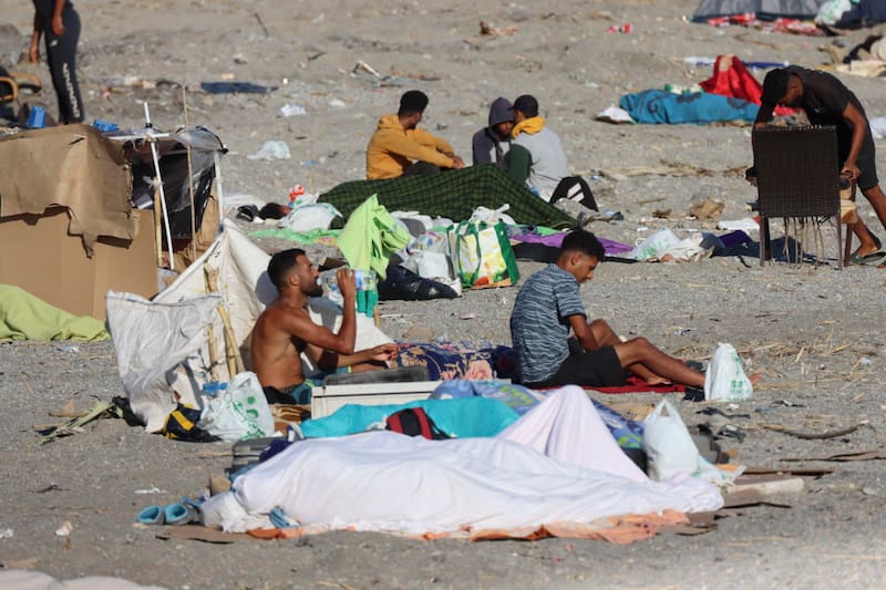 Migrantes acampando este sábado, en la playa El Trampolín de Ceuta (España).