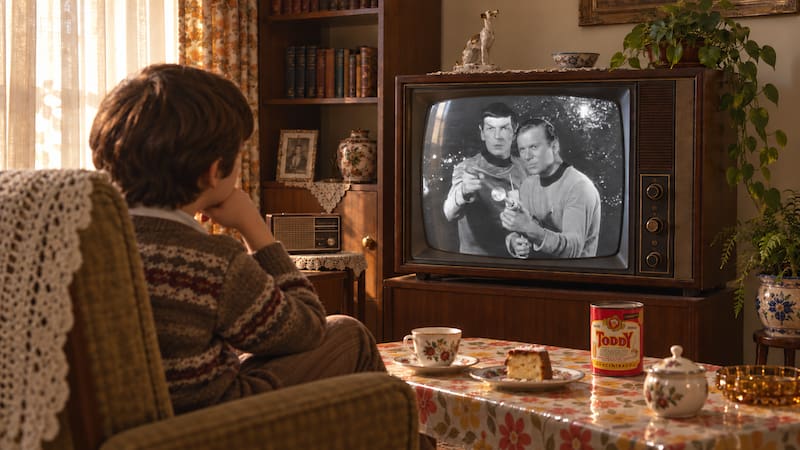Un chico mira *Viaje a las estrellas* en un televisor blanco y negro durante la merienda, en una escena ambientada en la Argentina de los años 60.