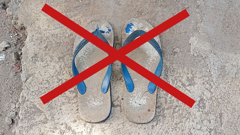 Surakarta, Indonesia - November 30, 2025: Blue flip-flops that are worn out and unfit for use, the color of the sandals is dull and some parts are peeling and broken.