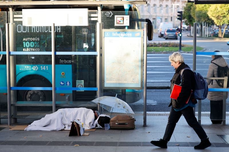MADRID, 01/12/2025.- Una persona sin hogar duerme en una parada de autobús en Madrid, este lunes. El primer día de diciembre arranca con temperaturas mínimas bajo cero en la Comunidad de Madrid, con heladas débiles generalizadas en la región, según el pronóstico de la Agencia Estatal de Meteorología (Aemet). Las mínimas estarán descenso mientras las máximas subirán ligeramente superando los diez grados. Los cielos estarán velados de nubes altas y el viento soplará flojo variables. EFE/ Mariscal