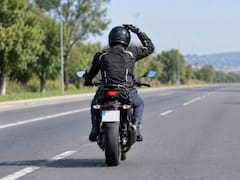 Qué significa que un motociclista se toque el casco y cómo actuar correctamente