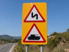 Qué significa la señal de tránsito de dos triángulos con borde rojo sobre amarillo con un tanque y una curva doble