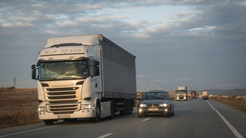 Transporte de carga y autos pequeños compartiendo la mísma autopista.