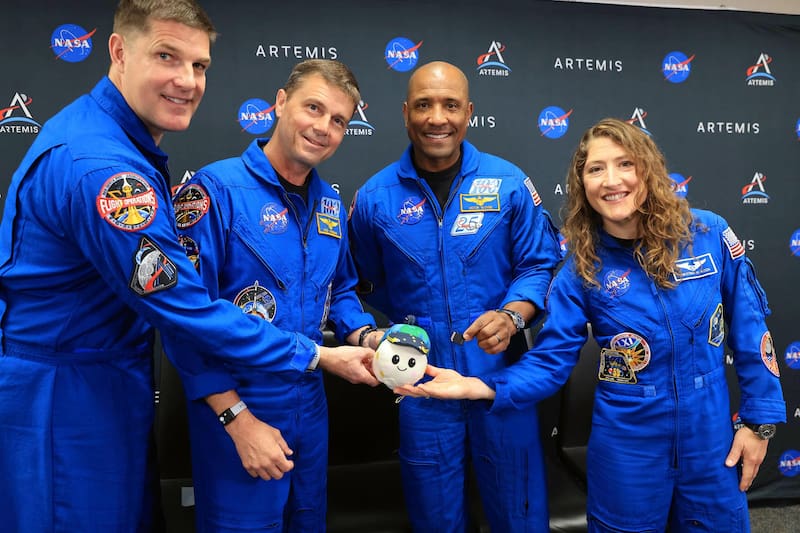 De izquierda a derecha el especialista de misión, Jeremy Hansen, de la Agencia Espacial Canadiense (CSA); el comandante Reid Wiseman, el piloto Victor Glover, y la especialista de misión Christina Koch, sosteniendo Rise, la mascota lunar e indicador de gravedad cero para el vuelo de prueba alrededor de la luna.
