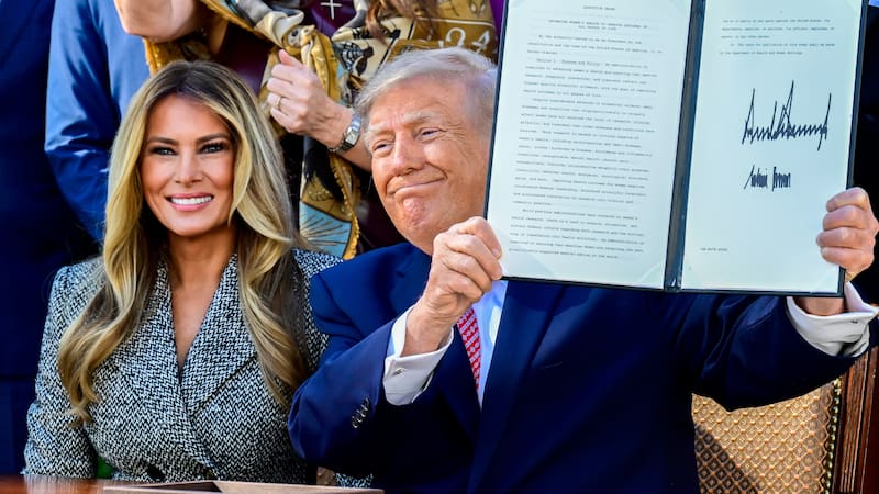 US First Lady Melania Trump, left, and US President Donald Trump display a signed executive order (EO) during a signing ceremony in the Rose Garden of the White House in Washington, DC, US, on Monday, Oct. 19, 2026. The executive order will establish a women's health office at the National Institutes of Health (NIH). Photographer: Ron Sachs/CNP/Bloomberg