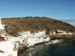 Esta sorprendente playa oculta con arena negra queda en el país: atrae por su paisaje de casas blancas y rocas