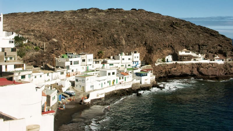 Esta sorprendente playa oculta con arena negra queda en el país: atrae por su paisaje de casas blancas y rocas.