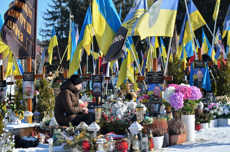 Personas visitan las tumbas de soldados ucranianos caídos en el cementerio de Lychakiv.