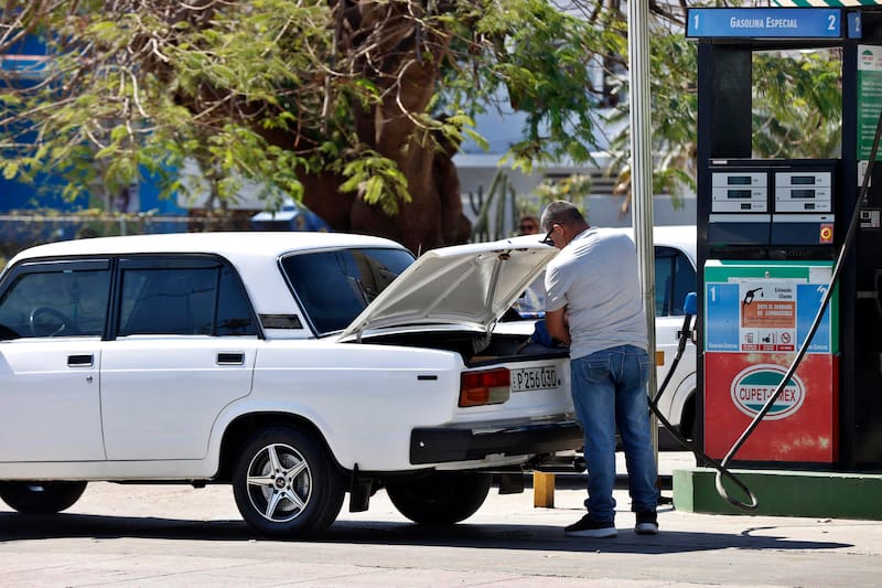 Una persona abastece con combustible un vehículo en La Habana