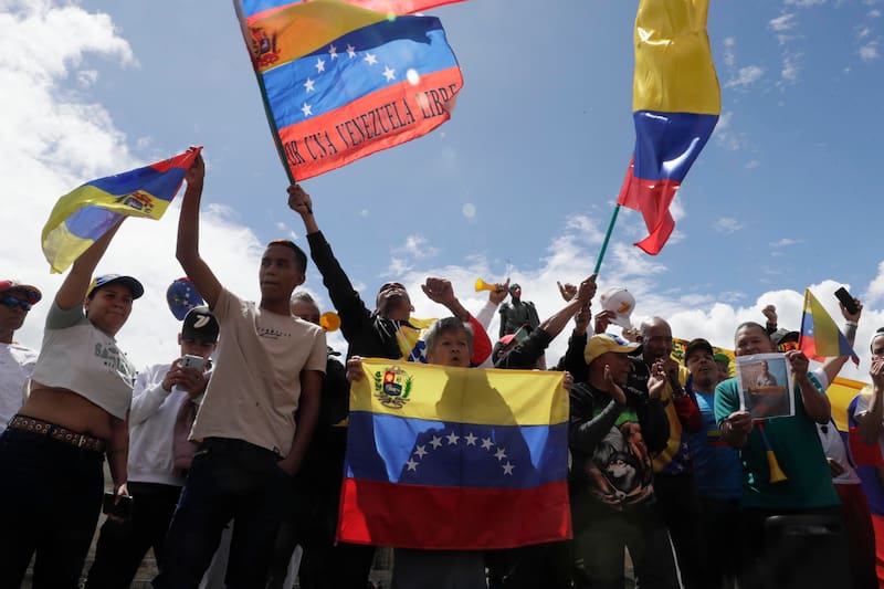 AME1774. BOGOTÁ (COLOMBIA), 03/01/2026.- Ciudadanos venezolanos celebran durante una manifestación este sábado, en la Plaza de Bolívar en Bogotá (Colombia). Estados Unidos capturó en la madrugada al presidente de Venezuela, Nicolás Maduro, y su esposa, Cilia Flores, en medio de un ataque a Venezuela que afectó a varios estados y a la capital, Caracas, por orden del presidente de Estados Unidos, Donald Trump, que calificó el operativo como "brillante". EFE/ Carlos Ortega