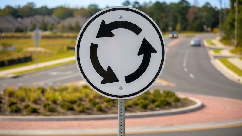 What the traffic sign with three black arrows forming a circle means and what drivers should do when they see it.