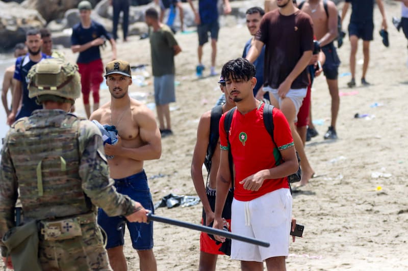 CEUTA, 31/07/2026.- Varios migrantes en la costa española de Ceuta, este viernes. El número de cadáveres encontrados en las últimas horas en la costa de la ciudad española de Ceuta tras la entrada masiva de personas procedentes de Marruecos asciende ya a 43, informaron a EFE fuentes policiales. Las fuerzas de seguridad y los servicios de emergencia siguen localizando algunos cuerpos de las miles de personas, sobre todo marroquíes y argelinos, que se lanzaron al mar desde las costas marroquíes de Castillejos para intentar alcanzar la costa ceutí a nado en los últimos días; y no se descarta que la cifra continúe aumentando. EFE/ Reduan Dris