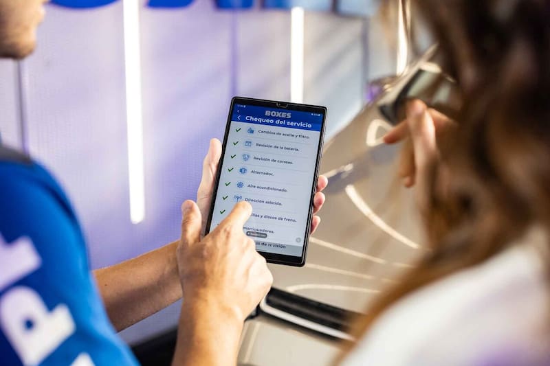 Personal de YPF Boxes con tablet en la mano.